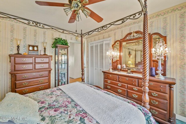 bedroom with a closet, a ceiling fan, and wallpapered walls