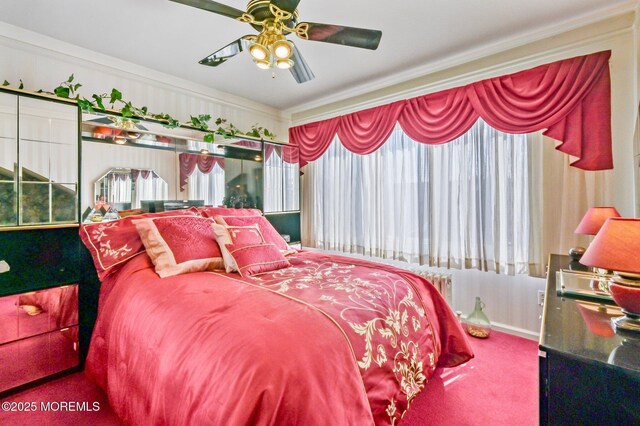 carpeted bedroom featuring ornamental molding, multiple windows, and a ceiling fan