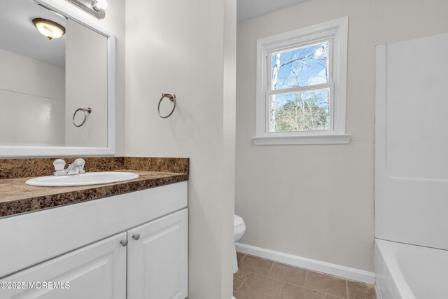 full bathroom with tile patterned flooring, toilet, vanity, and baseboards