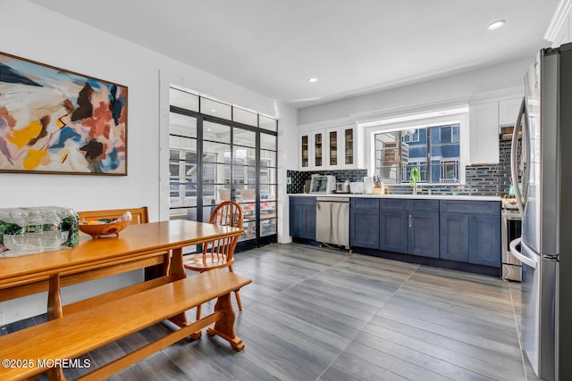 kitchen with plenty of natural light, appliances with stainless steel finishes, and white cabinetry