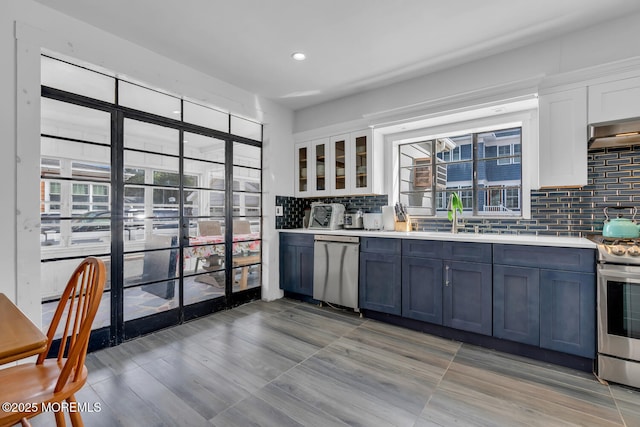 kitchen featuring plenty of natural light, appliances with stainless steel finishes, decorative backsplash, and a sink