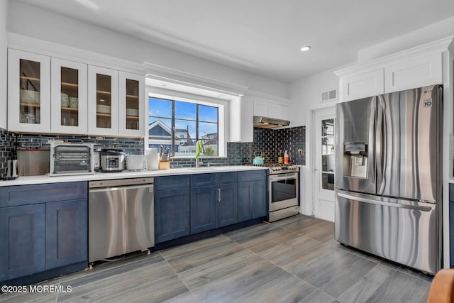 kitchen featuring stainless steel appliances, visible vents, white cabinetry, range hood, and light countertops
