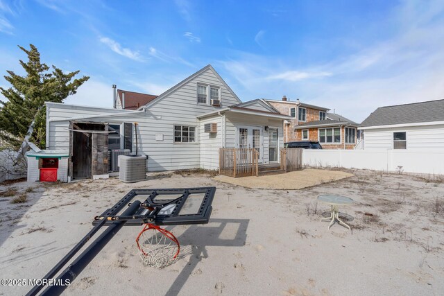 rear view of house featuring fence, french doors, and central AC unit