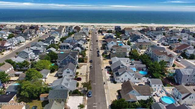 drone / aerial view with a beach view, a water view, and a residential view