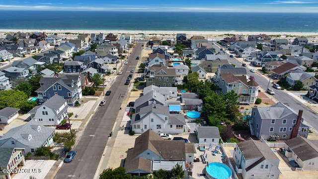 birds eye view of property featuring a beach view, a water view, and a residential view