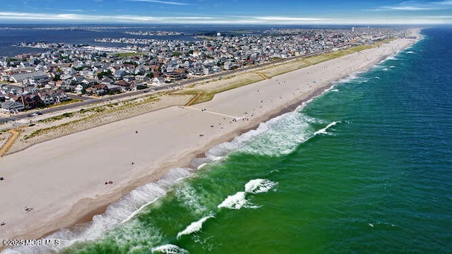 drone / aerial view featuring a beach view and a water view