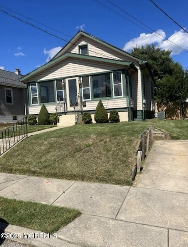 view of front of home with fence and a front lawn