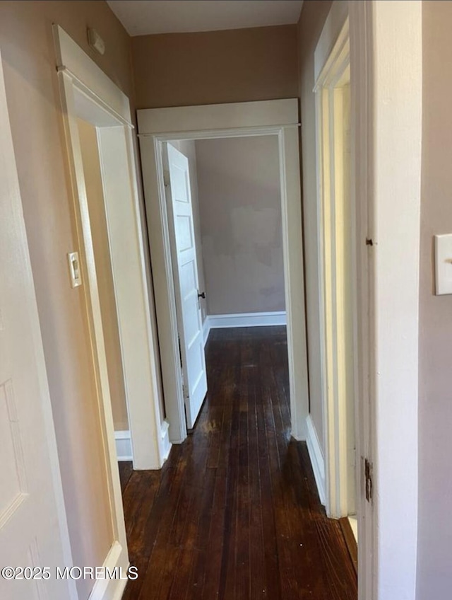 hall featuring baseboards and dark wood-style floors