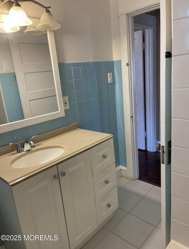 bathroom with wainscoting, tile patterned floors, vanity, and tile walls