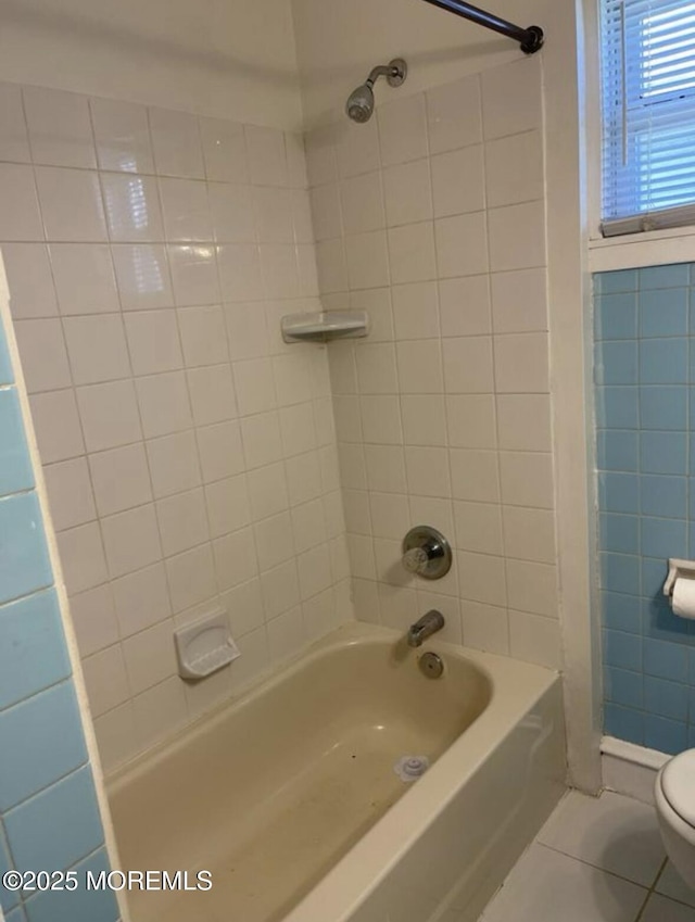 full bath featuring washtub / shower combination, tile patterned floors, and toilet