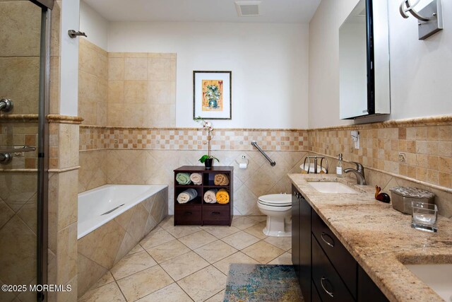 bathroom with a sink, toilet, visible vents, a tile shower, and a garden tub