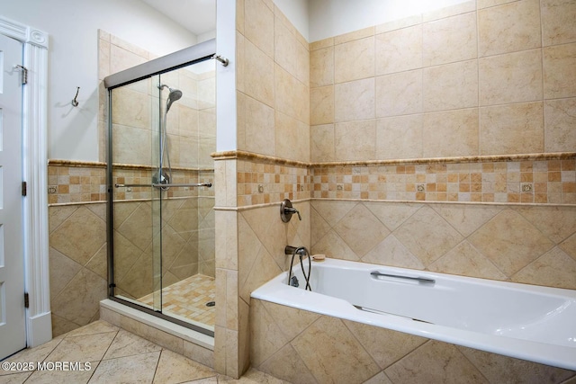 bathroom featuring a shower stall, tile patterned floors, tile walls, and a garden tub