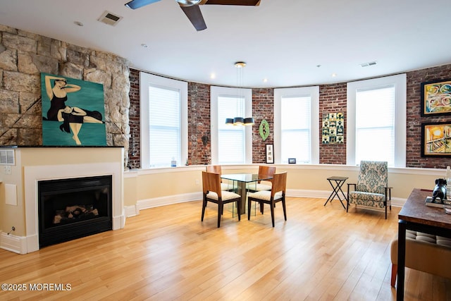 dining room featuring visible vents, ceiling fan, wood-type flooring, and a wealth of natural light