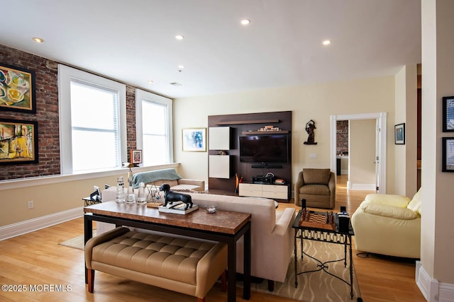 living room featuring brick wall, recessed lighting, light wood-style floors, and baseboards