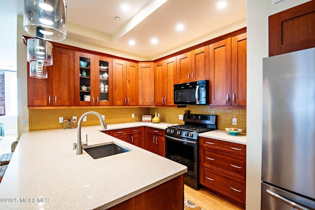 kitchen with glass insert cabinets, recessed lighting, appliances with stainless steel finishes, a sink, and decorative backsplash