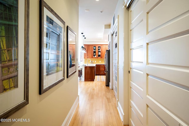 hall featuring light wood-style floors and a sink