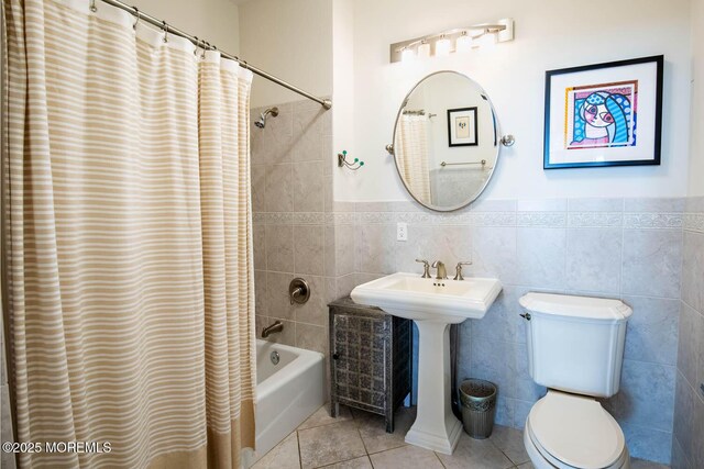 bathroom featuring toilet, tile patterned flooring, shower / tub combo with curtain, and tile walls