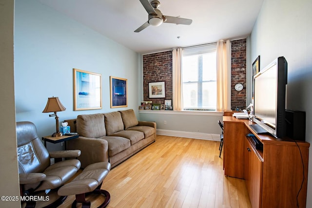 living room featuring light wood-style floors, baseboards, and a ceiling fan