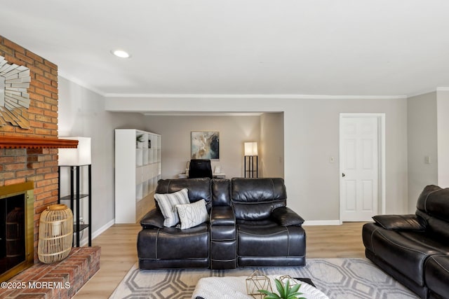 living room with a fireplace, crown molding, and wood finished floors