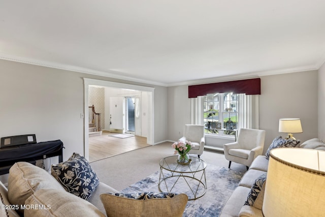 living area featuring light colored carpet, baseboards, ornamental molding, and stairs