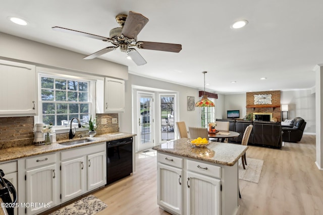 kitchen featuring white cabinetry, dishwasher, a sink, light wood finished floors, and backsplash