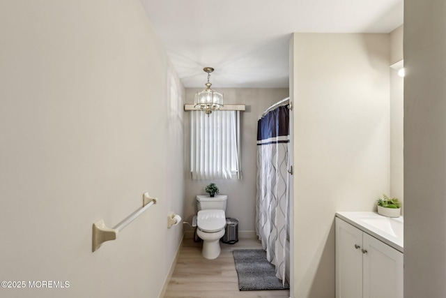 full bathroom featuring baseboards, curtained shower, a notable chandelier, toilet, and wood finished floors