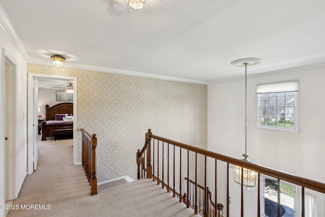 hallway with ornamental molding, an upstairs landing, carpet, and wallpapered walls