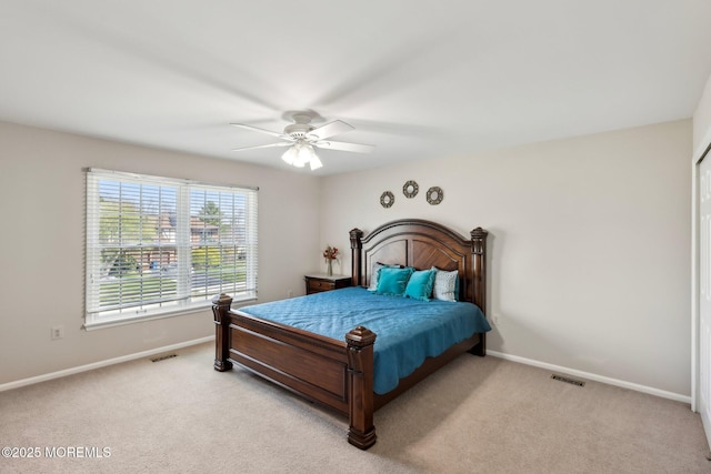 bedroom with light carpet, visible vents, baseboards, and ceiling fan