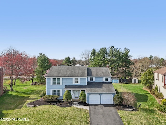 view of front of house with a front yard, a garage, and driveway
