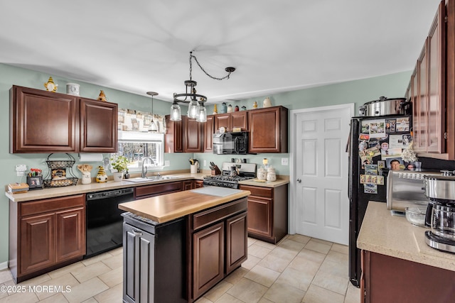 kitchen featuring light tile patterned floors, a sink, black appliances, pendant lighting, and a kitchen island