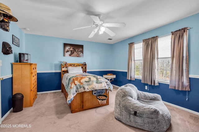 carpeted bedroom with visible vents, baseboards, and a ceiling fan