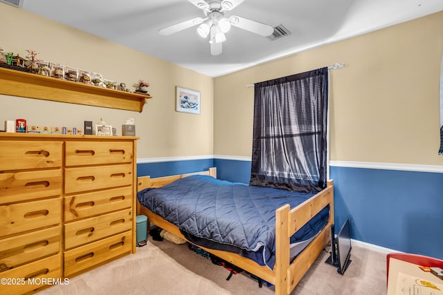 bedroom with light colored carpet, a ceiling fan, and visible vents