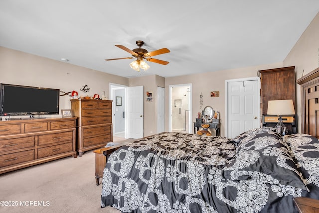 bedroom featuring light carpet, a ceiling fan, and connected bathroom