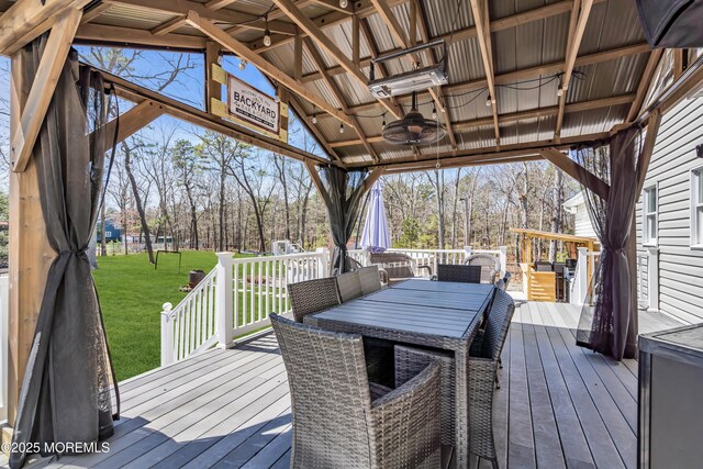 deck with a yard, ceiling fan, and outdoor dining area