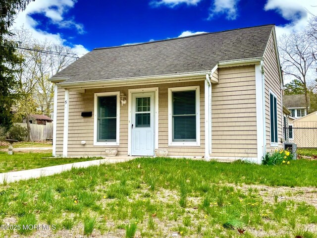 5 Laurel Ave, Toms River, NJ 08753 - view of front facade with a front yard, fence, and roof with shingles