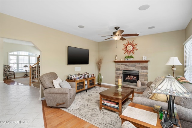 1306 Wickford Ln, Lanoka Harbor, NJ 08734 - living room featuring arched walkways, a stone fireplace, baseboards, and ceiling fan