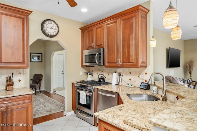 1306 Wickford Ln, Lanoka Harbor, NJ 08734 - kitchen with light stone countertops, ceiling fan, stainless steel appliances, arched walkways, and a sink