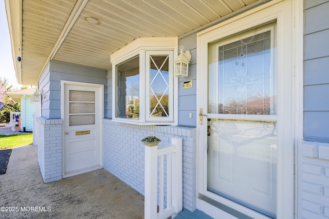doorway to property with brick siding