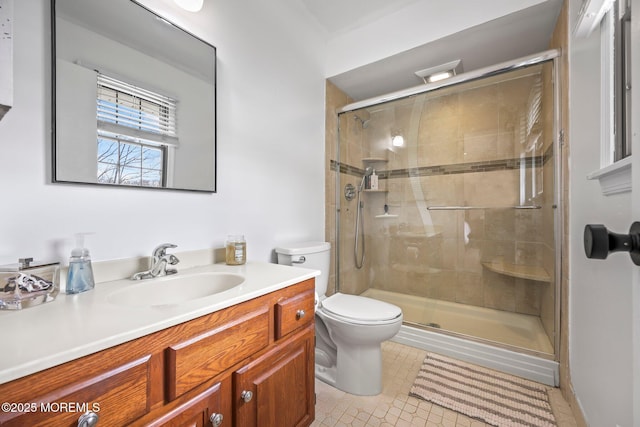 bathroom with a stall shower, tile patterned floors, vanity, and toilet