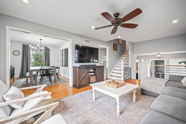 living room featuring recessed lighting, visible vents, light wood finished floors, and ceiling fan with notable chandelier