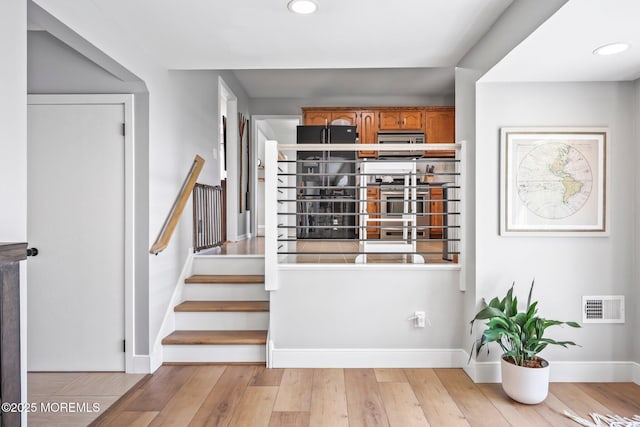 stairway featuring baseboards, wood finished floors, visible vents, and recessed lighting