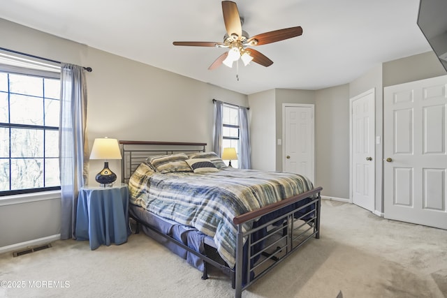 bedroom with light carpet, baseboards, a ceiling fan, and visible vents