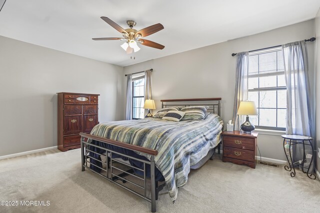 bedroom with light carpet, ceiling fan, and baseboards