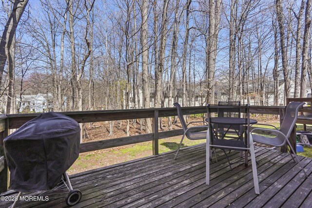 deck with a grill and outdoor dining space