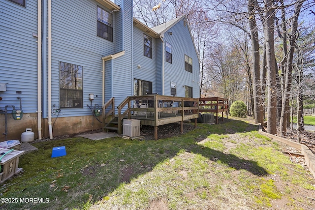 rear view of property with central AC unit, a deck, a lawn, and a chimney