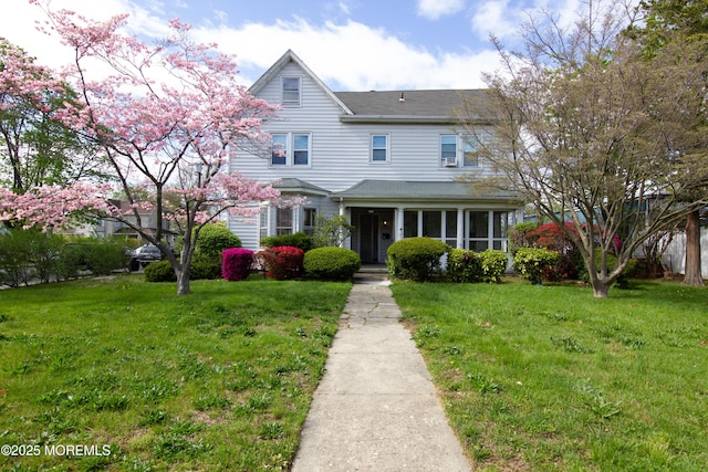 view of front of house with a shingled roof and a front yard