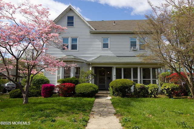 view of front of home featuring roof with shingles and a front lawn