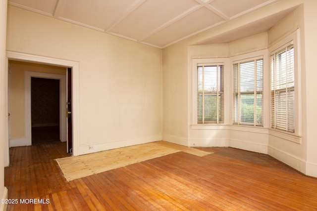 empty room featuring baseboards and hardwood / wood-style flooring