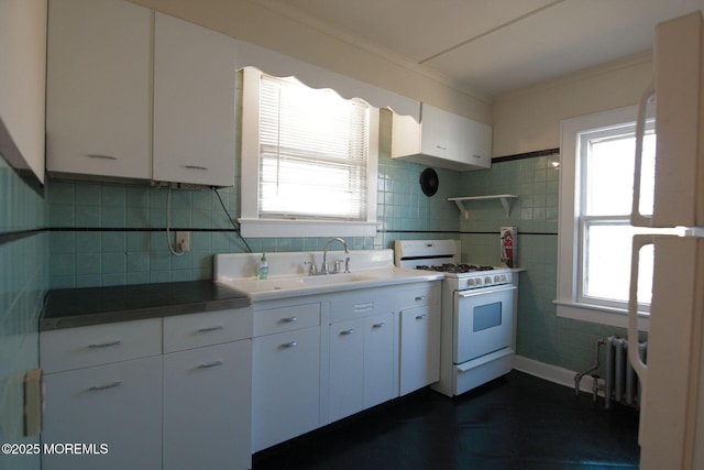 kitchen with radiator, white cabinets, white gas stove, and ornamental molding