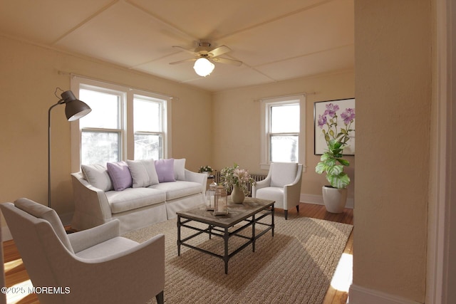 living area with baseboards, ceiling fan, a healthy amount of sunlight, and wood finished floors